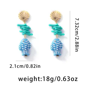 Dettaglio orecchini conchiglia e pesce blu stile spiaggia, gioielli in ceramica marina.