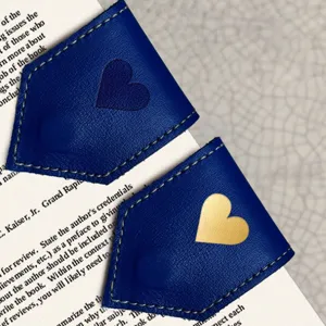 Leather magnetic bookmark detail view, blue rhombus page marker with heart design, reading accessory.