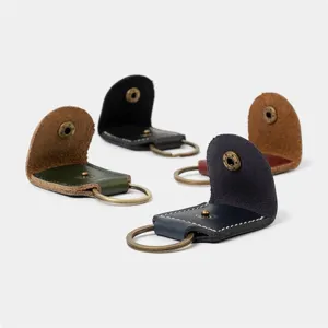 Detailed view of portable leather guitar pick cases and keychains in assorted colors for musicians.