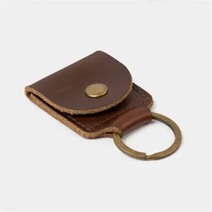 Close-up detail of the brown leather guitar pick holder showing fine stitching and metal snap.