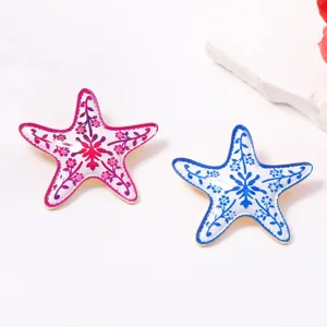 Spilla stella marina smaltata chic in rosa e blu, ideale per lo stile di vacanza estiva.