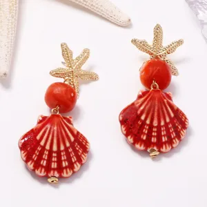 Orecchini pendenti da donna con conchiglia in ceramica rossa e stella marina stile spiaggia.
