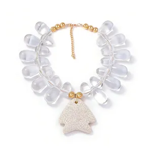 Statement beaded necklace with clear teardrop beads, gold chain, and unique fish pendant.