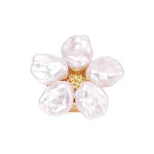 Detalle de botón de flor de perla barroca, estambres dorados, accesorio chic para uso diario.