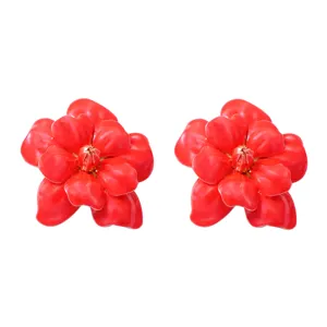 Close-up detail of bold red camellia flower earrings, vibrant floral jewelry design for women.