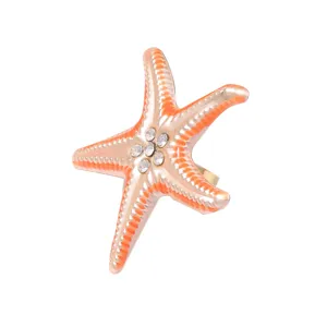 Starfish ring detail shot showing orange gradient enamel and sparkling crystal center accents.