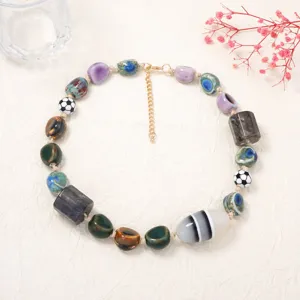 Primo piano dettagliato della collana di perline in ceramica irregolare con trame uniche.