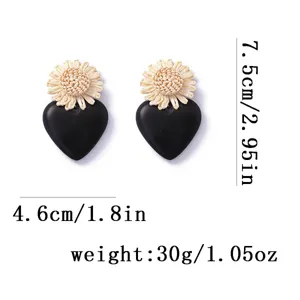 Detail view of the chic black heart acrylic and woven raffia statement earrings.