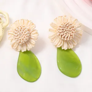 Handmade raffia flower and green acrylic leaf drop earrings for women, boho style.
