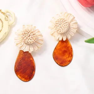 Raffia woven flower earrings with amber acrylic teardrop pendants for summer vacation style.