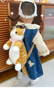 Detailed shot of cute ginger cat plush backpack worn by child, soft furry animal design daypack.