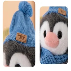 Primo piano dettagliato di peluche pinguino con cappello e sciarpa in maglia blu