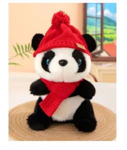 Primo piano dettagliato del simpatico panda di peluche con cappello di lana rosso e sciarpa.