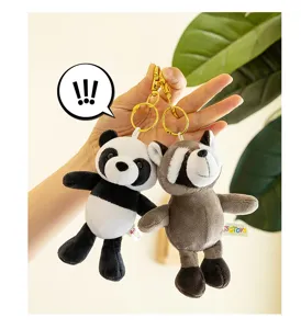 Cute cartoon panda and raccoon plush keychains, detailed close-up shot with gold clasps.