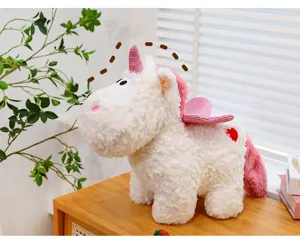 Dettaglio peluche unicorno soffice carino, corno e ali glitterate rosa con dettaglio cuore.