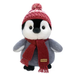 Cute penguin plush toy with knit hat and scarf, soft winter stuffed animal desktop decor.
