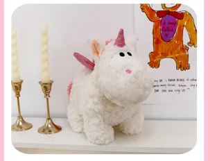 Primo piano dettagliato del morbido peluche unicorno bianco con grandi occhi e ali rosa.