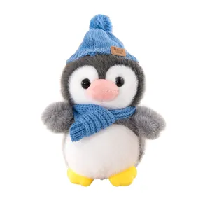 Simpatico peluche pinguino cartone animato con cappello e sciarpa di lana blu, morbido regalo.
