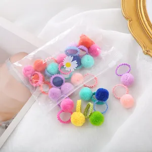 Dettaglio mini elastici capelli con pon pon in peluche colorati, accessori morbidi per bimbi.