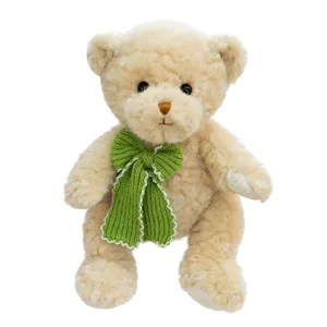 Cute plush teddy bear toy with a green knitted bow, soft stuffed animal gift for kids and girls.