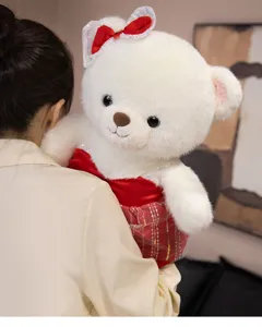 Details of the white plush teddy bear in a red wedding dress with a cute bow ribbon.