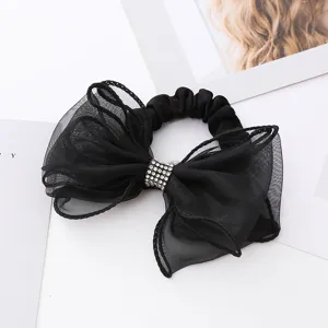 Chouchou de cheveux en résille noire avec grand nœud et strass, accessoire élégant.
