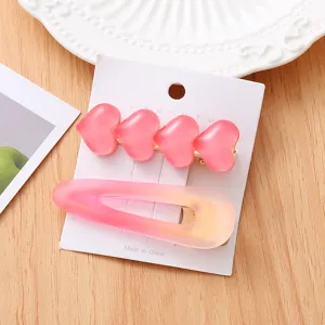 Vue de détail d'un ensemble de pinces à cheveux cœur rose avec une jolie barrette à dégradé mignon.