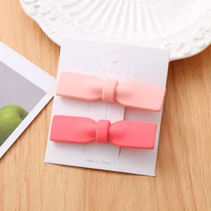 Détail de la pince à cheveux nœud rose mat montrant le joli design mignon et la texture lisse.