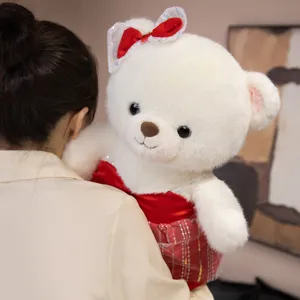 Cute plush teddy bear doll wearing a red wedding dress and bow, soft gift for romantic occasions.