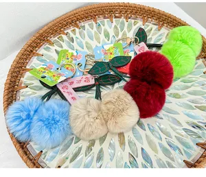 Fluffy plush pom-pom keychains with leaf charm, cute bag pendants and car key accessories.