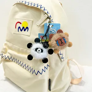 Canvas backpack with cute plush animal keychains, casual daily school bag for students.