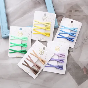 Vue détaillée d'un ensemble de pinces à cheveux métalliques croisées aux teintes pastel.