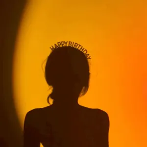 Détail de serre-tête d'anniversaire avec lettrage strass élégant et design de fête atmosphérique.