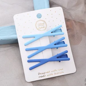 Vue détaillée d'un joli ensemble de 3 pinces à cheveux en métal croisées bleues sur carte.