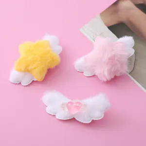 Close-up detail shot of cute plush star and wing hair clips with sweet heart design.