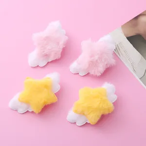 Close-up detail shot of cute plush star hair clips with white angel wings in pink and yellow.