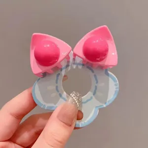 Close-up detail van schattige Y2K dopamine roze kattenoor haarclip met lichtblauwe bloemenbasis.