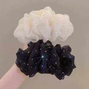 Close-up detail of large mesh hair claw clip with sparkling rhinestones, elegant black and white.