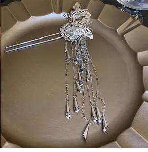 Close-up van zilverkleurige legering traditionele haarspeld met vlinders en delicate metalen kwastjes.