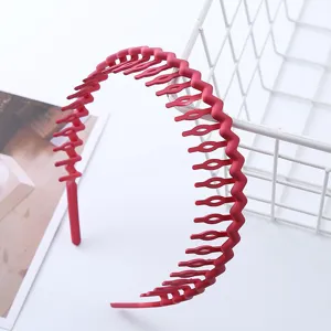 Detail view of red wave teeth plastic headband for washing face, anti-slip hair accessory.