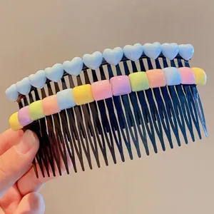 Close-up detail of cute colorful heart and square decorative hair insert comb for kids hair styling.