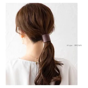 Vista detallada del pasador de coleta de cuero PU marrón, accesorio para el cabello minimalista.