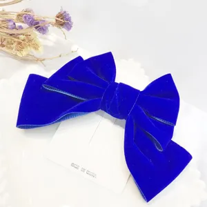 Stunning blue velvet bow hair clip detail, elegant fabric hair accessory for women styling.