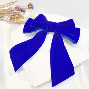 Detailed view of the elegant Klein blue velvet bow hair clip, showcasing fine fabric texture.
