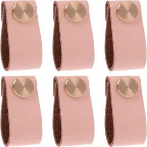 Détail de poignée de meuble en cuir rose, bouton métallique sur boucle souple.