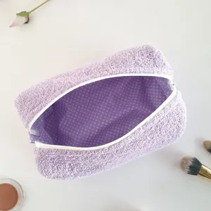 Detailansicht der lila Frottee Kosmetiktasche mit geräumigem gepunkteten Innenfutter.