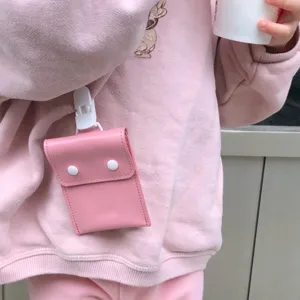 Detail view of the portable pink mini storage pouch clipped on clothing for easy access.