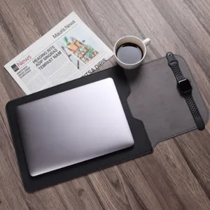Detail shot of PU leather laptop sleeve and folding desk mat on wood table with office props.