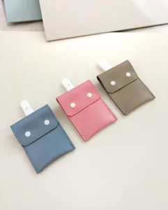 Portable baby pacifier storage bag with white clip and snap buttons, multi-color.