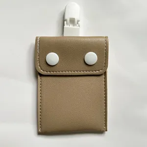 Close-up of portable pacifier storage bag with snap buttons and clip, detail view.